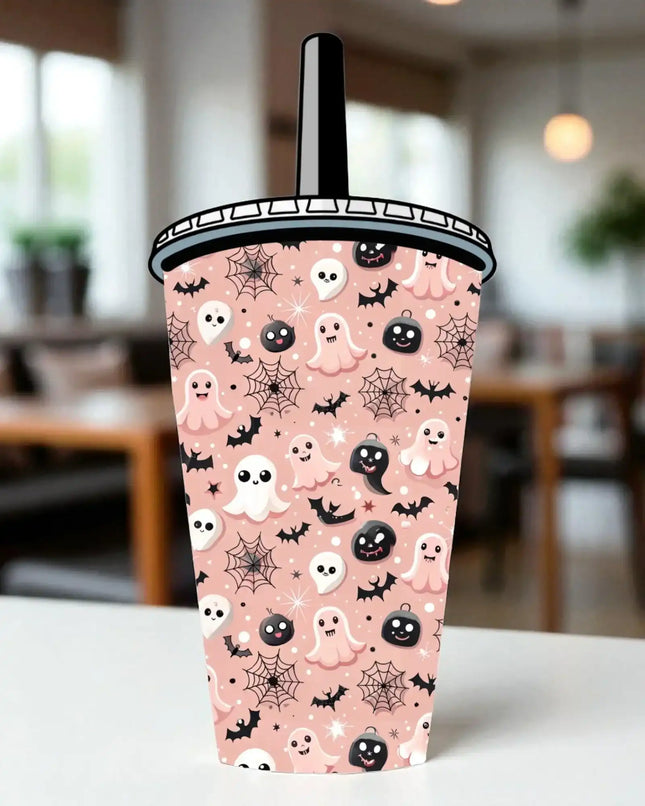 A Halloween-themed cup with a pink background and various ghost and spider motifs, including bats, skulls, and pumpkins.