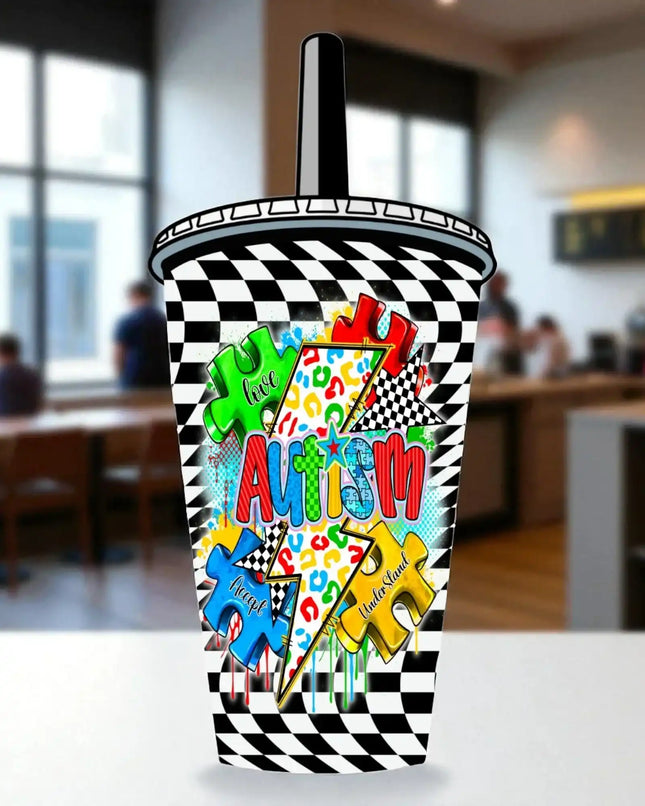 A colorful and vibrant cupcake cup with the word "Autism" prominently displayed on it, surrounded by various puzzle pieces and checkered patterns.