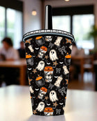 A Halloween-themed cup with a black background and various spooky and festive elements such as ghost, bats, stars, and a pumpkin.